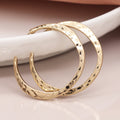 Worn gold irregular hammered open hoop earrings