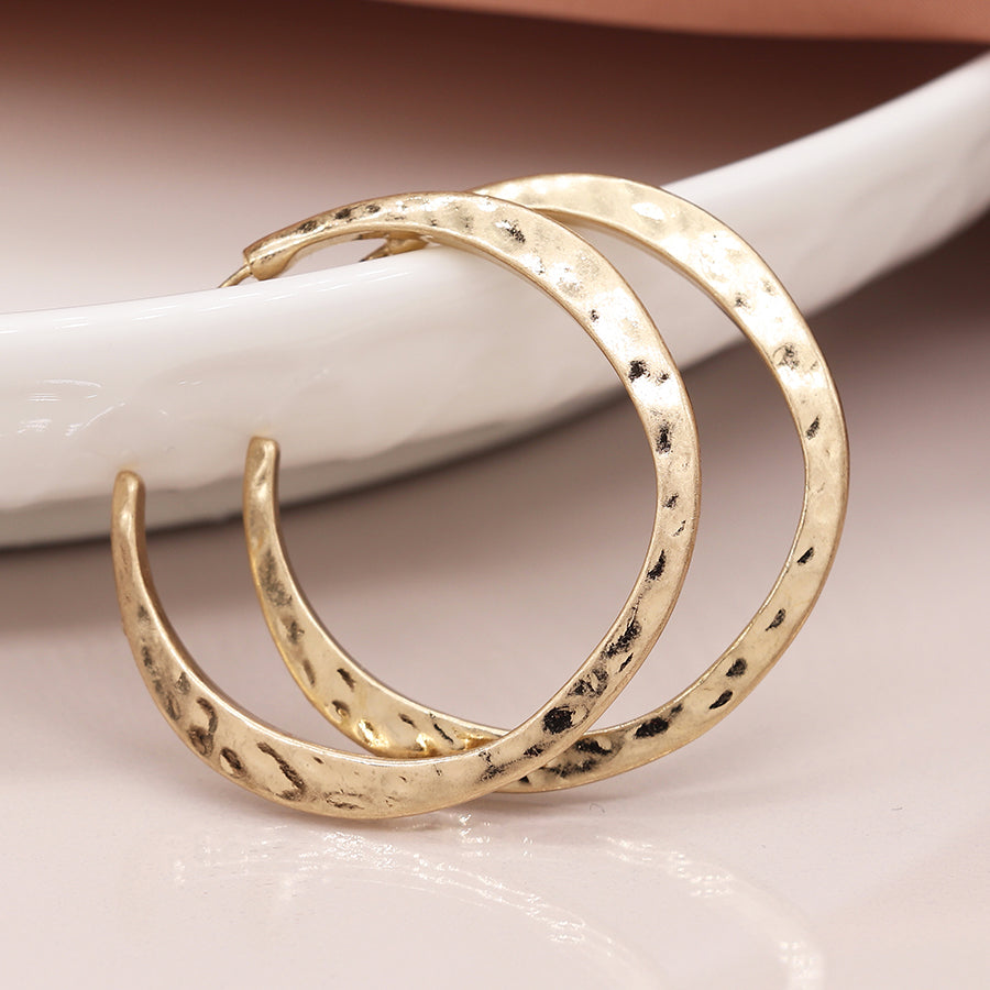 Worn gold irregular hammered open hoop earrings