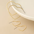 Golden mixed size textured heart earrings